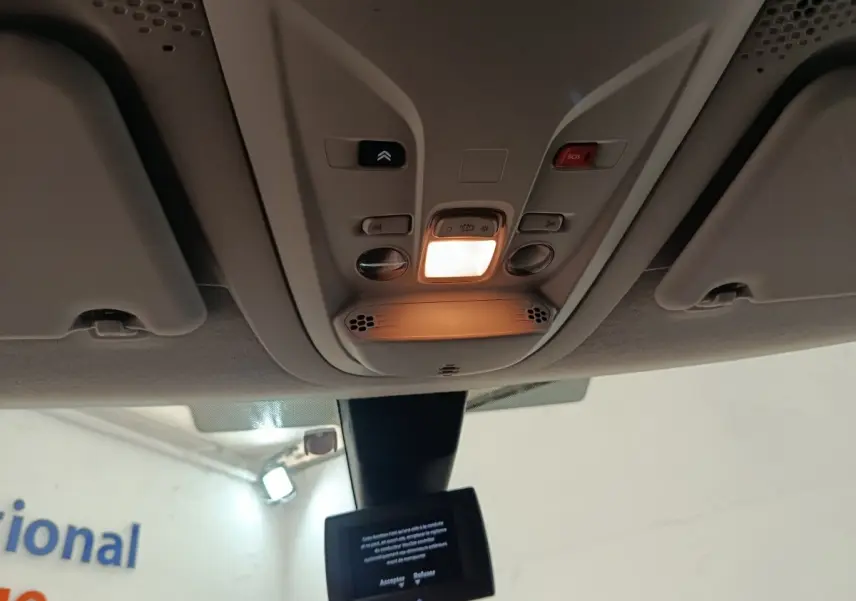 Vue intérieure du plafonnier allumé avec commandes et écran tactile du Citroën Berlingo blanc 2020.
