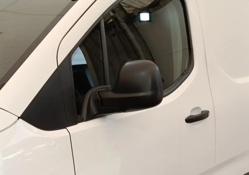 Vue latérale côté conducteur d'un Citroën Berlingo blanc 2020 avec rétroviseur noir et poignée de porte noire.