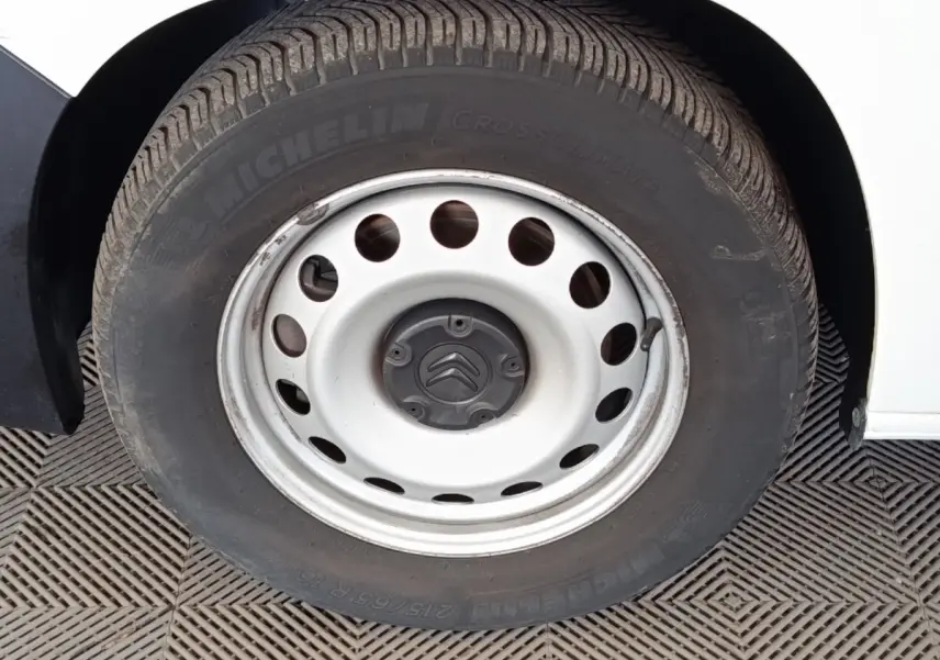 Gros plan sur la roue acier blanche avec logo Citroën d’un Citroën Berlingo blanc, côté gauche.