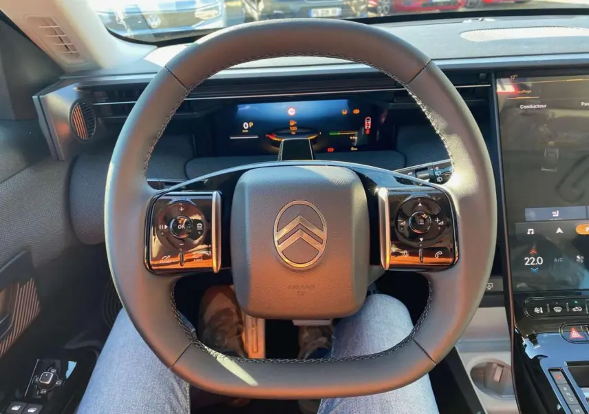 Vue intérieure centrée sur le volant du Citroën C5 Aircross 2026, avec tableau de bord numérique et écran tactile visible.
