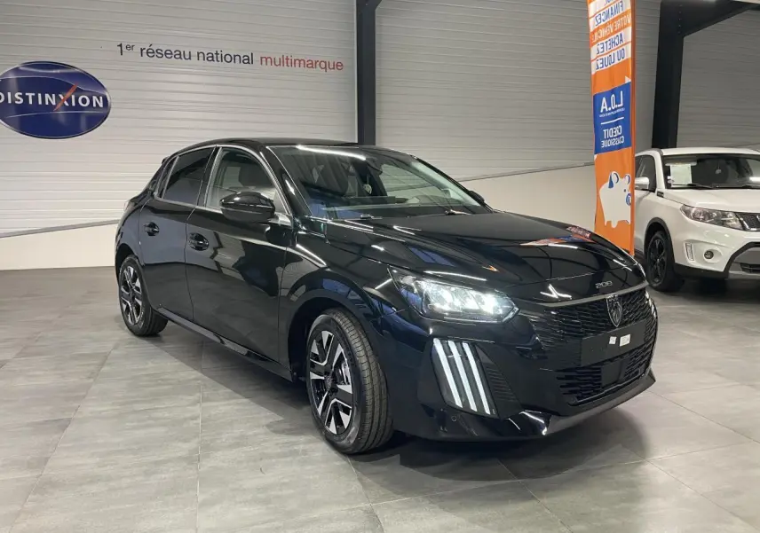 Peugeot 208 hybride noir métallisé vue 3/4 avant avec feux LED et jantes alliage bi-ton dans un showroom.