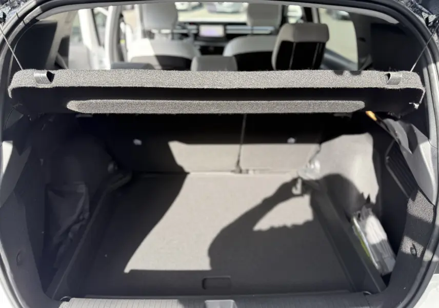 Vue intérieure du coffre ouvert du Citroën C3 Aircross blanc banquise, avec banquette arrière et cache-bagages visibles.
