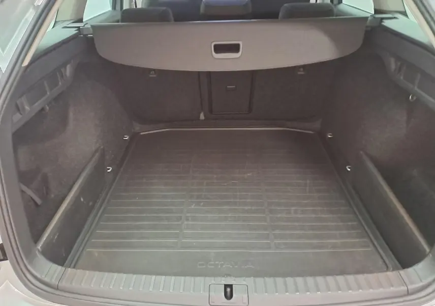 Vue intérieure du coffre spacieux d'une Skoda Octavia Combi 2025, avec tapis de coffre noir marqué Octavia.