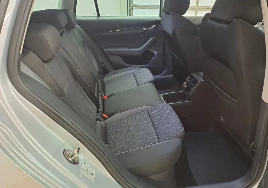 Vue intérieure côté gauche des sièges arrière en tissu gris foncé d'une Skoda Octavia Combi 2025 gris argent.