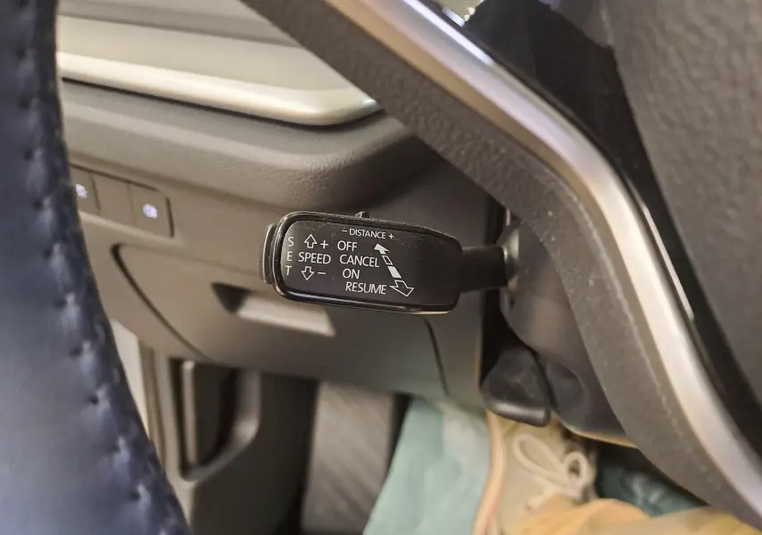 Gros plan sur la commande du régulateur de vitesse adaptatif dans l'habitacle d'une Skoda Octavia Combi gris argent.