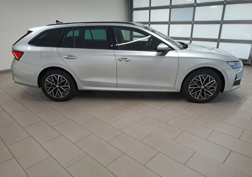 Vue latérale droite d'une Skoda Octavia Combi 2025 gris argent avec jantes alliage noires polies et vitres surteintées.