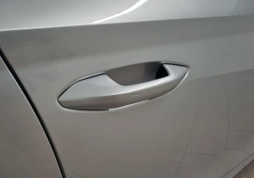 Poignée de porte gris argentée en gros plan sur une SKODA OCTAVIA COMBI 2025 côté gauche.