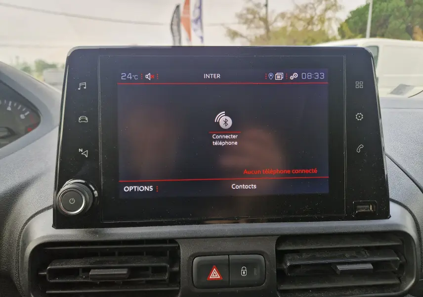 Écran tactile central du tableau de bord du Peugeot Partner blanc, affichant la connexion Bluetooth au téléphone.