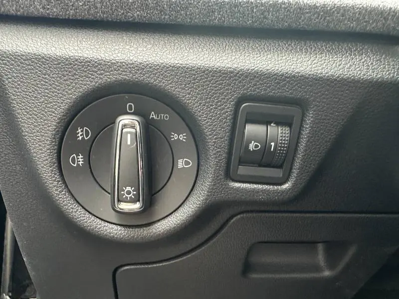 Gros plan sur la commande des phares et réglage d'intensité dans l'habitacle noir d'une Skoda Scala 2025.