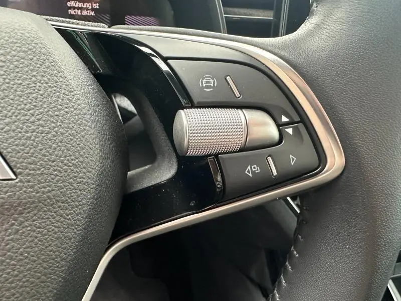 Gros plan sur les commandes multifonctions côté gauche du volant cuir noir de la Skoda Scala 2025.