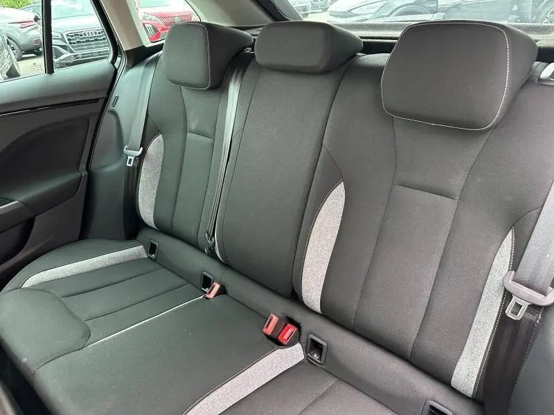 Vue intérieure de la banquette arrière noire et grise du Skoda Scala 2025, avec appuie-têtes et ceintures visibles.