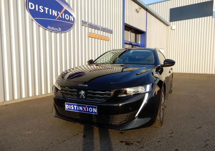 Peugeot 508 SW noir Perla Nera vue 3/4 avant droit, avec calandre distinctive et feux LED allumés.