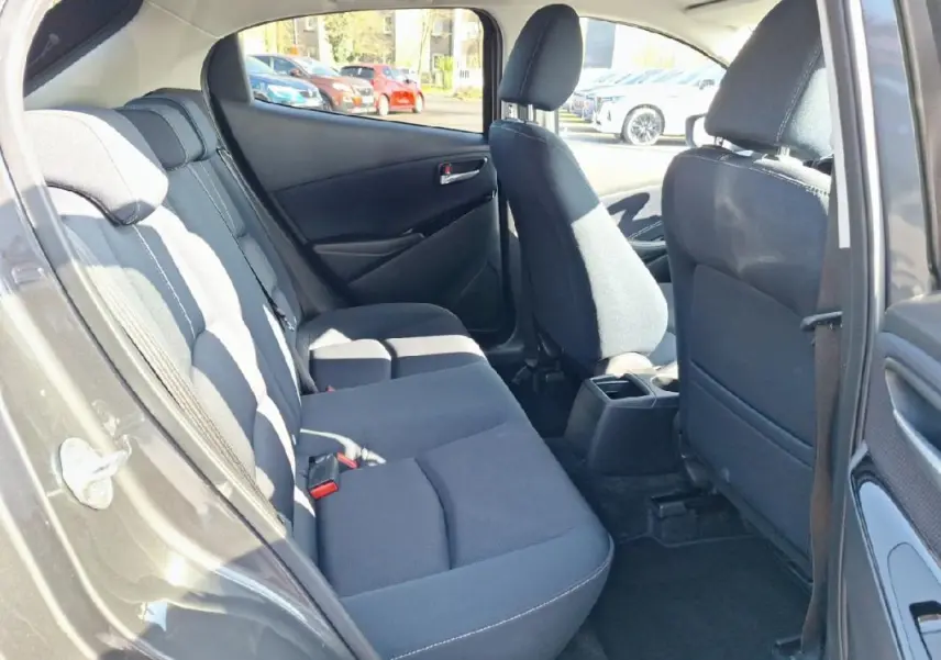 Vue intérieure côté droit sur les sièges arrière noirs d'une Mazda2 gris 2023, avec porte ouverte.