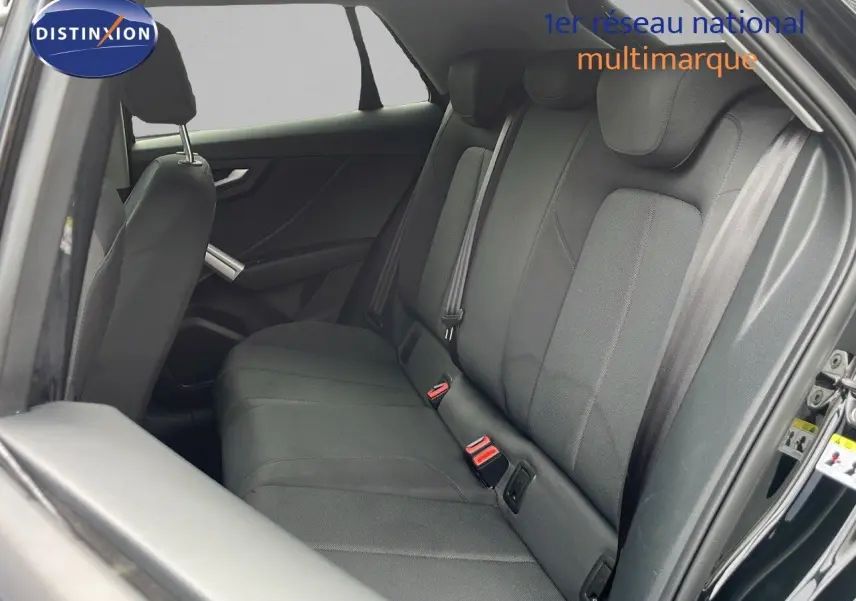 Vue intérieure côté droit montrant les sièges arrière en tissu noir d'un Audi Q2 35 TFSI S-Line 2023 noir mito metal.