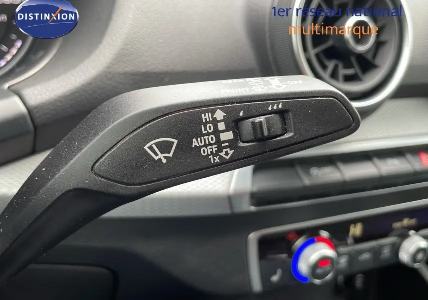 Le levier d'essuie-glace avec réglages HI, LO, AUTO sur le tableau de bord d'un Audi Q2 noir Mito Metal.