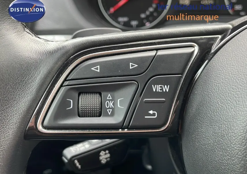 Gros plan sur les commandes multifonctions au volant en cuir noir de l'Audi Q2 35 TFSI S-Line 2023.