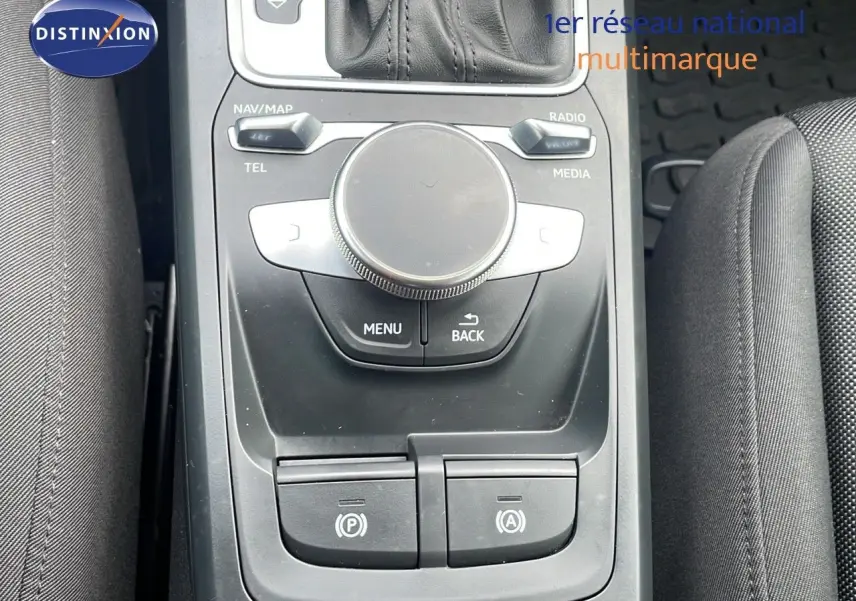 Gros plan sur la console centrale noire de l'Audi Q2 35 TFSI S-Line 2023 avec commandes multimédia et frein électrique.