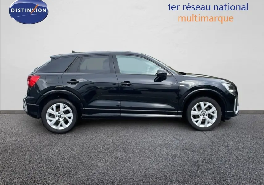 Profil côté gauche d'un Audi Q2 35 TFSI S-Line noir mito metal avec jantes alliage et lignes dynamiques visibles.