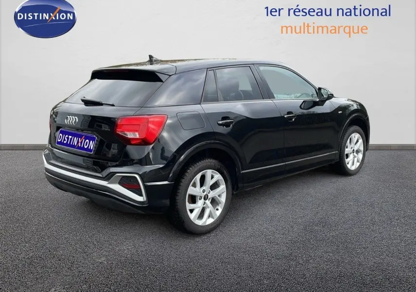Audi Q2 noir mito metal vue 3/4 arrière côté droit, avec jantes argentées et feux arrière rouges visibles