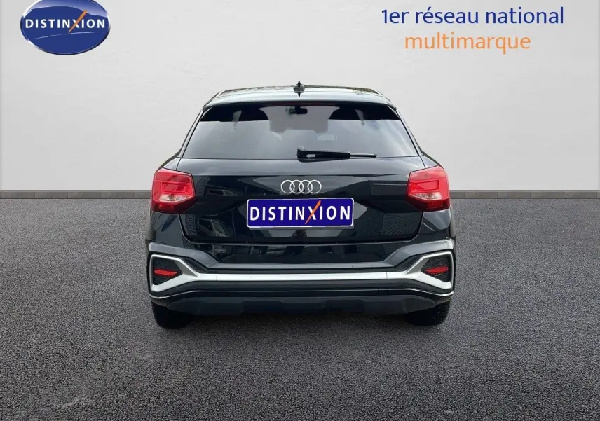 Vue arrière d'un Audi Q2 35 TFSI noir mito metal avec feux arrière rouges et logo quatre anneaux bien visible.