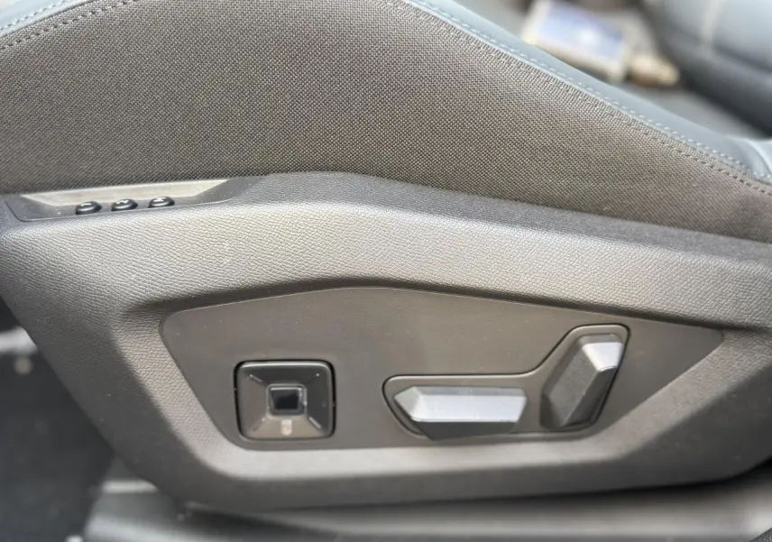 Détail des commandes de réglage électrique du siège conducteur en tissu bleu sur Citroën C5 Aircross 2026.