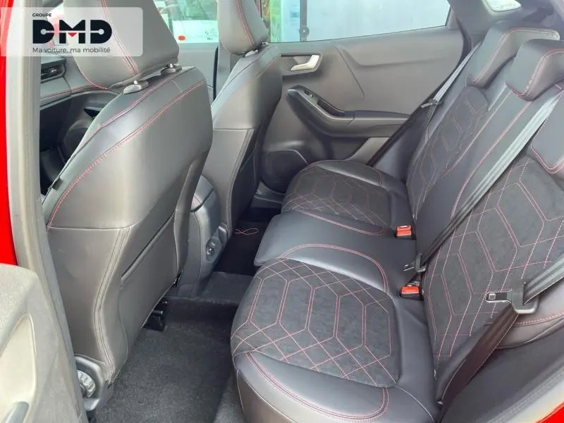 Vue intérieure des sièges arrière du Ford Puma rouge, avec sellerie noire et surpiqûres rouges visibles.