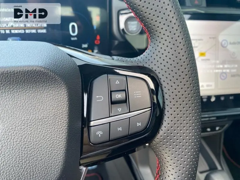 Gros plan sur les commandes multifonctions du volant perforé avec surpiqûres rouges d’un Ford Puma rouge 2026.