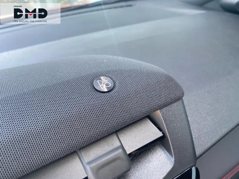 Gros plan sur le haut-parleur Bang & Olufsen intégré au tableau de bord du Ford Puma rouge.