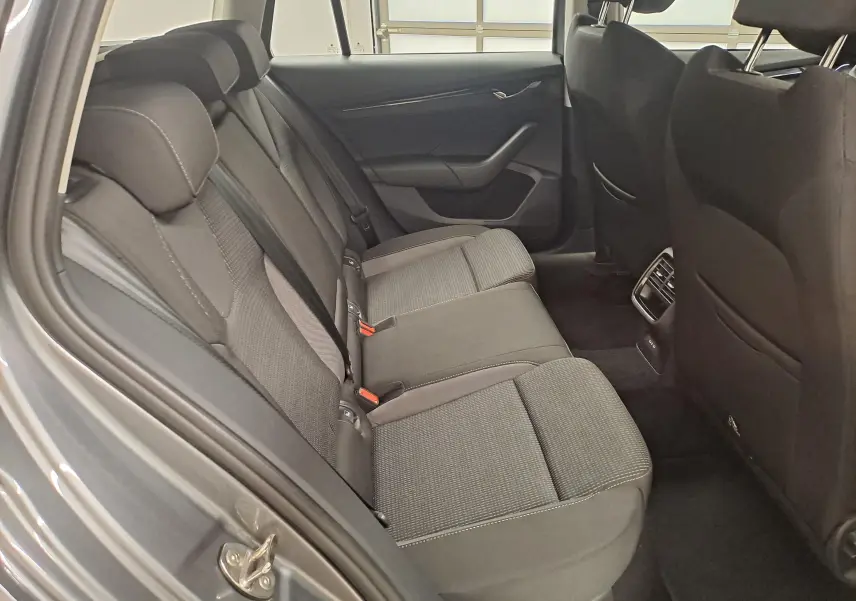 Vue intérieure des sièges arrière en tissu gris de la Skoda Octavia Combi 2024, côté gauche ouvert.