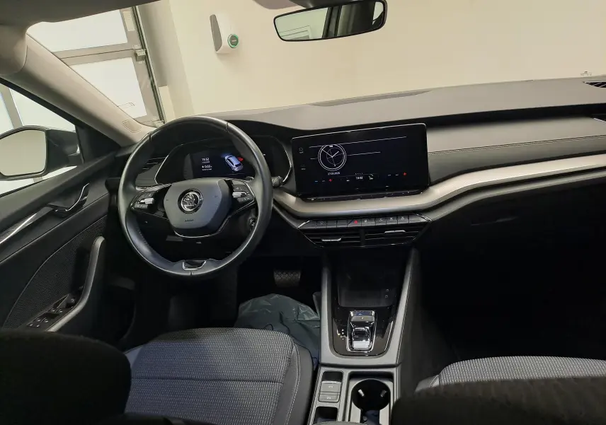 Vue intérieure avant de la Skoda Octavia Combi 2024, tableau de bord moderne avec écran tactile et volant multifonction noir.