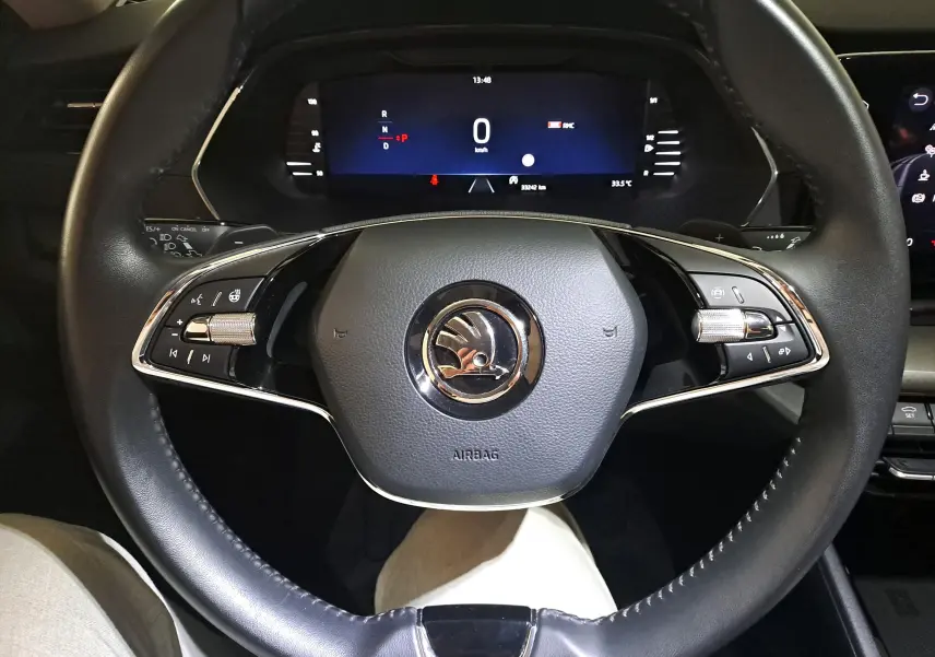 Vue rapprochée du volant noir avec commandes intégrées et tableau de bord numérique de la Skoda Octavia Combi 2024.