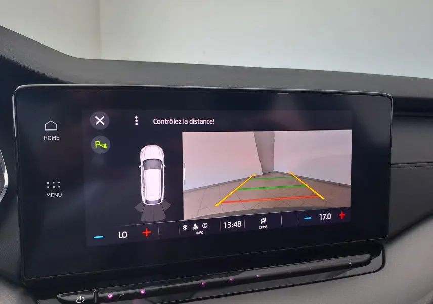 Écran tactile intérieur de la Skoda Octavia Combi 2024 montrant la caméra de recul et l'alerte de distance en mode stationnement.