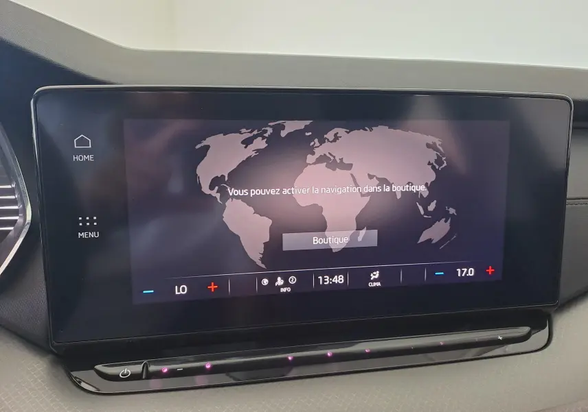 Écran tactile central du tableau de bord de la Skoda Octavia Combi 2024, affichant une carte du monde et les commandes climatiques.