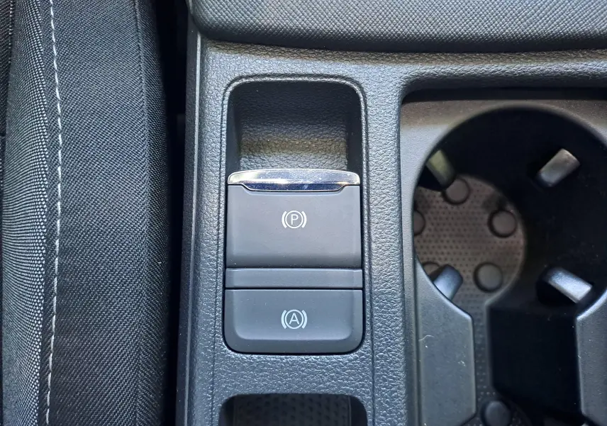 Gros plan sur les boutons de frein à main électronique et d'arrêt/démarrage automatique dans la console centrale d'une Skoda Octavia Combi 2024.
