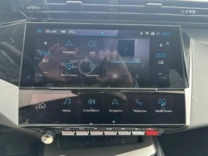 Vue rapprochée de l’écran tactile central de la Peugeot 308 1.2 Hybrid 145ch Allure, affichant les commandes multimédia et climatisation.
