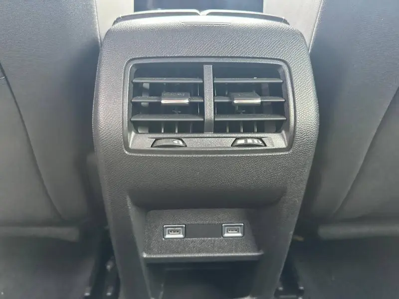 Vue rapprochée des aérateurs arrière et des deux ports USB noirs dans l'habitacle d'une Peugeot 308 blanche.