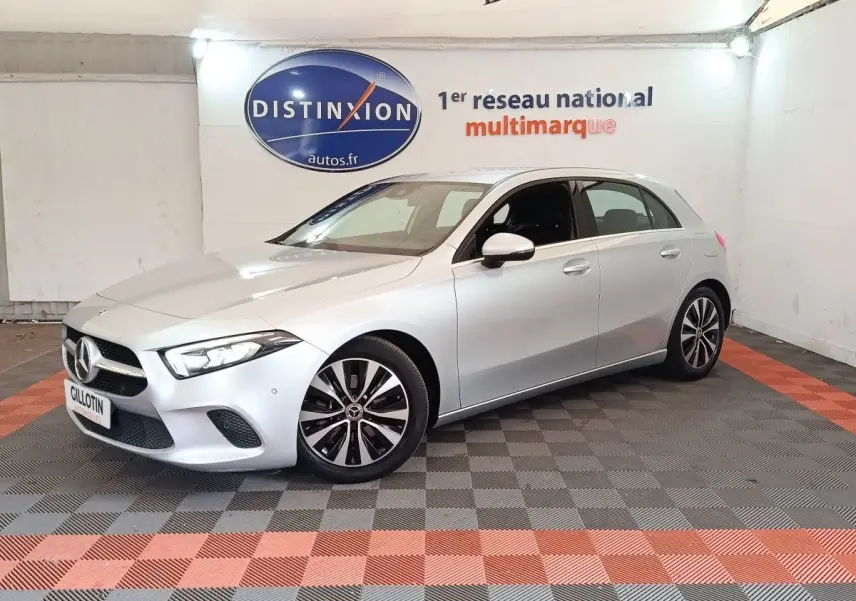 Vue 3/4 avant d'une Mercedes Classe A 180 d Business Line gris clair avec jantes distinctives en concession.