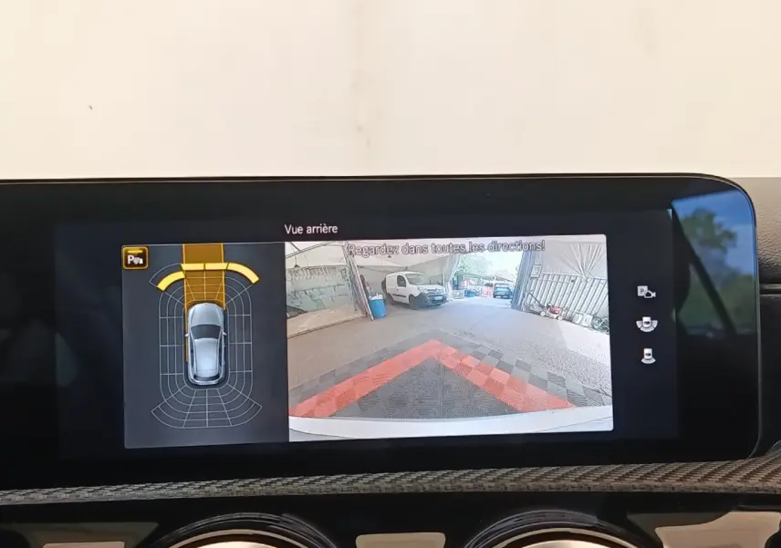 Écran tactile intérieur montrant la caméra de recul et l’aide au stationnement de la Mercedes Classe A gris clair.