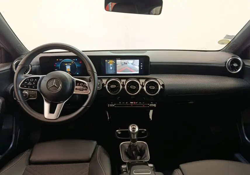 Vue intérieure frontale du tableau de bord noir et volant cuir de la Mercedes Classe A 180 d Business Line 2021.
