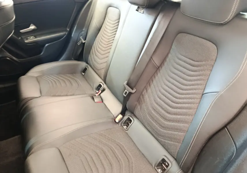 Vue intérieure de la banquette arrière en cuir noir de la Mercedes Classe A 180 d Business Line, côté droit.