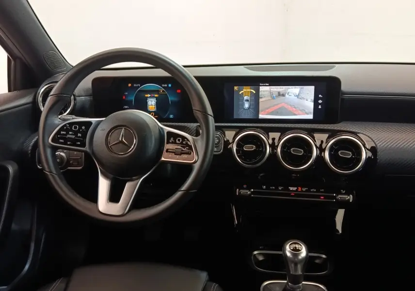Vue intérieure frontale du tableau de bord noir et volant cuir de la Mercedes Classe A 180 d Business Line 2021.