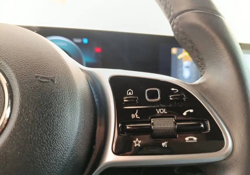 Gros plan sur le volant cuir multifonctions de la Mercedes Classe A 180 d Business Line, avec commandes de volume visibles.