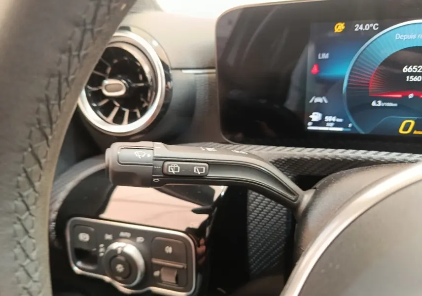 Gros plan sur la manette d’essuie-glace à gauche du volant dans l’habitacle d’une Mercedes Classe A gris clair 2021.