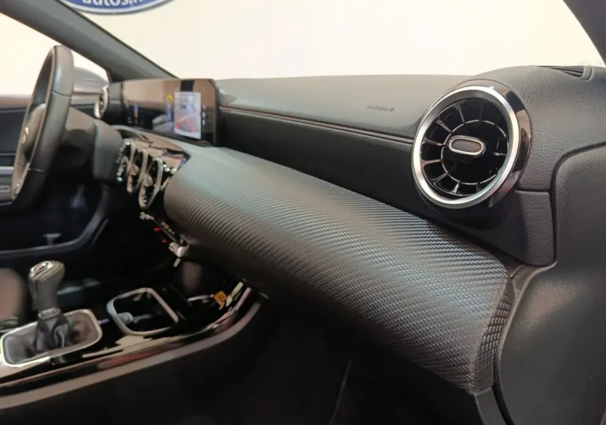 Vue intérieure côté passager du tableau de bord noir texturé et volant cuir de la Mercedes Classe A 180 d Business Line 2021.