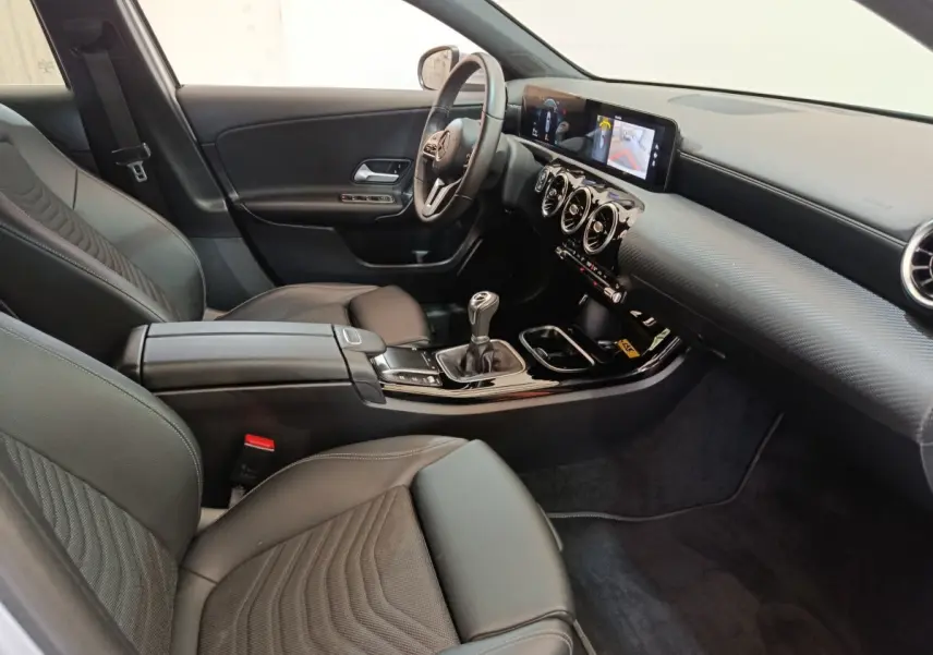 Intérieur noir de la Mercedes Classe A 180 d Business Line 2021, vue côté conducteur avec tableau de bord digital et boîte manuelle.