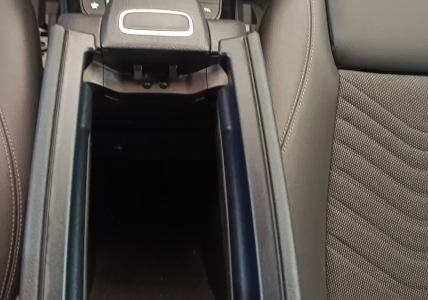 Vue plongeante sur la console centrale ouverte et les sièges gris cuir de la Mercedes Classe A 180 d Business Line 2021.