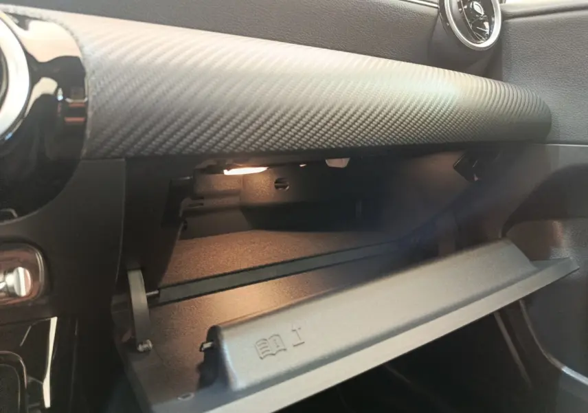 Vue intérieure du vide-poche ouvert côté passager d'une Mercedes Classe A 180 d Business Line 2021 gris clair.