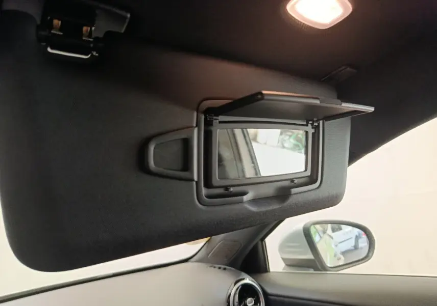 Détail du pare-soleil côté conducteur avec miroir éclairé dans l'habitacle gris clair d'une Mercedes Classe A 180 d Business Line 2021.