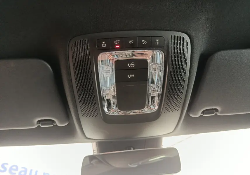 Vue intérieure en plongée du plafonnier noir avec commandes d’appel d’urgence et éclairage dans une Mercedes Classe A gris clair.