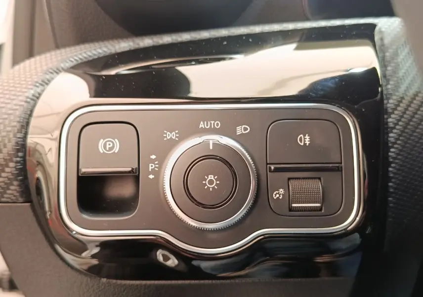 Gros plan sur le panneau de commandes d’éclairage noir brillant de la Mercedes Classe A 180 d Business Line 2021.